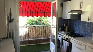 Una cocina con alacenas blancas, estufa y lavadora.