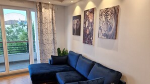 Een moderne woonkamer met een hoekbank, een houten salontafel en een potplant.