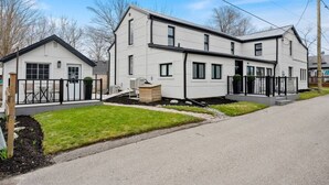 Ein modernes, zweistöckiges Haus mit Flachdach, einer Veranda und einer kleinen angebauten Garage.