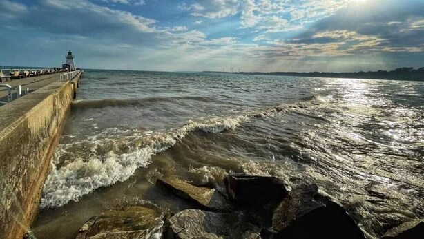 A pier extending into the sea with waves crashing against it. - Luxe Lodges on Lake Erie ~ Bunkie ~ Beach Access (Port Dover)