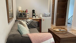 A compact living space with a sofa, a coffee machine, a microwave, and a small refrigerator. - Beautiful newly updated home in Boulder! Entrance on side of house up stairs. (Boulder)