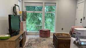 A spacious living area with a large window, a ceiling fan, and a wooden floor. - Beautiful newly updated home in Boulder! Entrance on side of house up stairs. (Boulder)