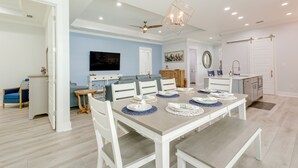 A dining area with a large table set for six, a ceiling fan, recessed lighting, and a kitchen in the background. - Bright Foley Home w/ Patio - 7 Mi to Wharf & Beach (Foley)