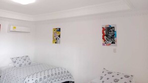 A bedroom with a bed, an air conditioner, and two posters on the wall. - Habitacion Extragrande Cerca al Parque Venezuela (Barranquilla)