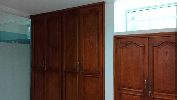 A room with a large wooden wardrobe and a window. - Habitacion Extragrande Cerca al Parque Venezuela (Barranquilla)