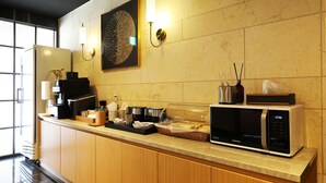 Une cuisine moderne équipée d’un four à micro-ondes, d’une machine à café et agrémentée d’un élément décoratif mural.