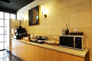 Una cocina moderna con microondas, cafetera y un adorno de pared.