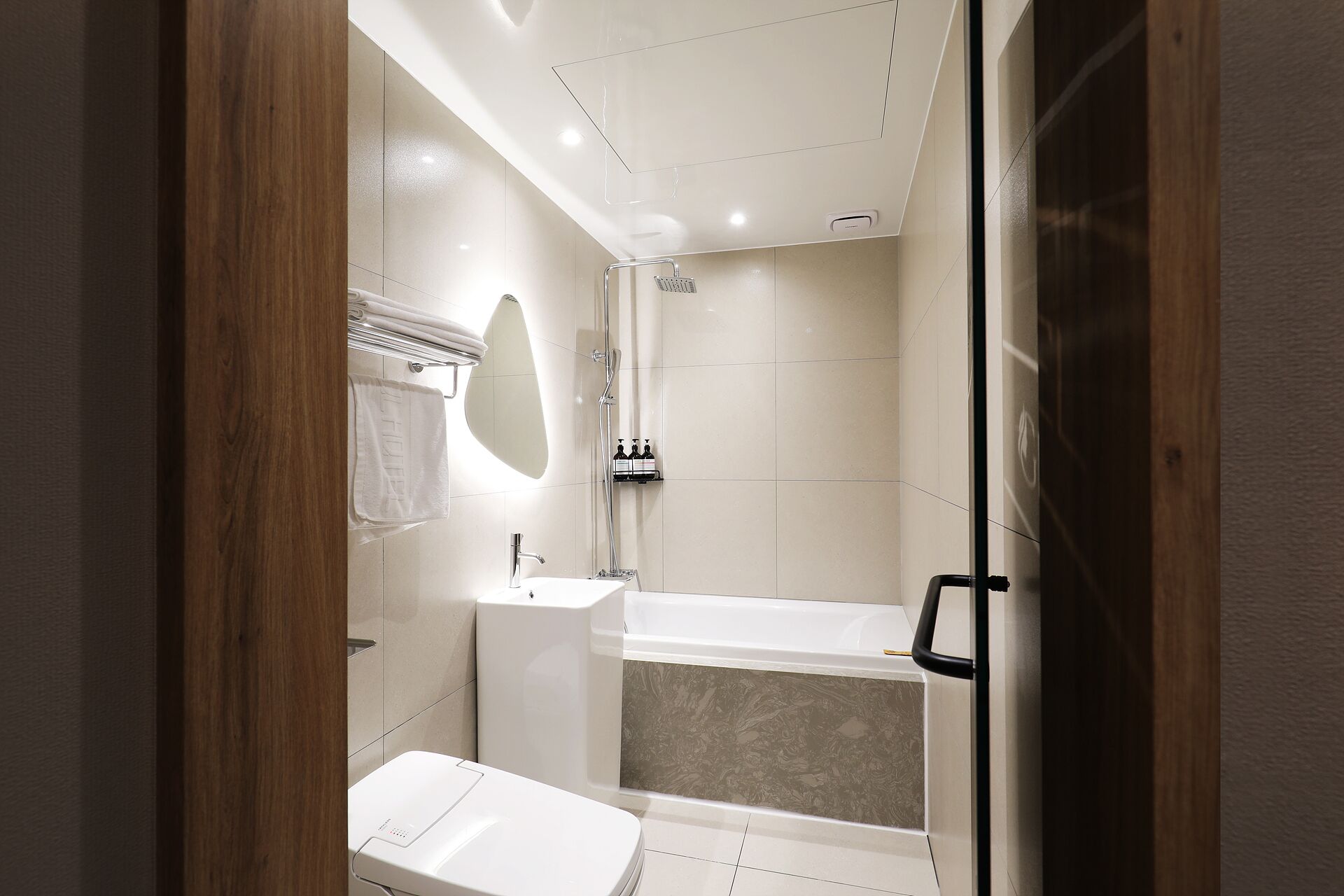 Een moderne badkamer met douche, toilet en wastafel.