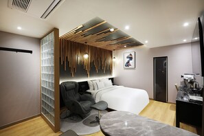 Un dormitorio moderno con cama, dos sillas, un escritorio y baño.