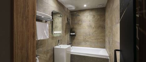 Un baño moderno con una bañera, un lavabo y un inodoro.