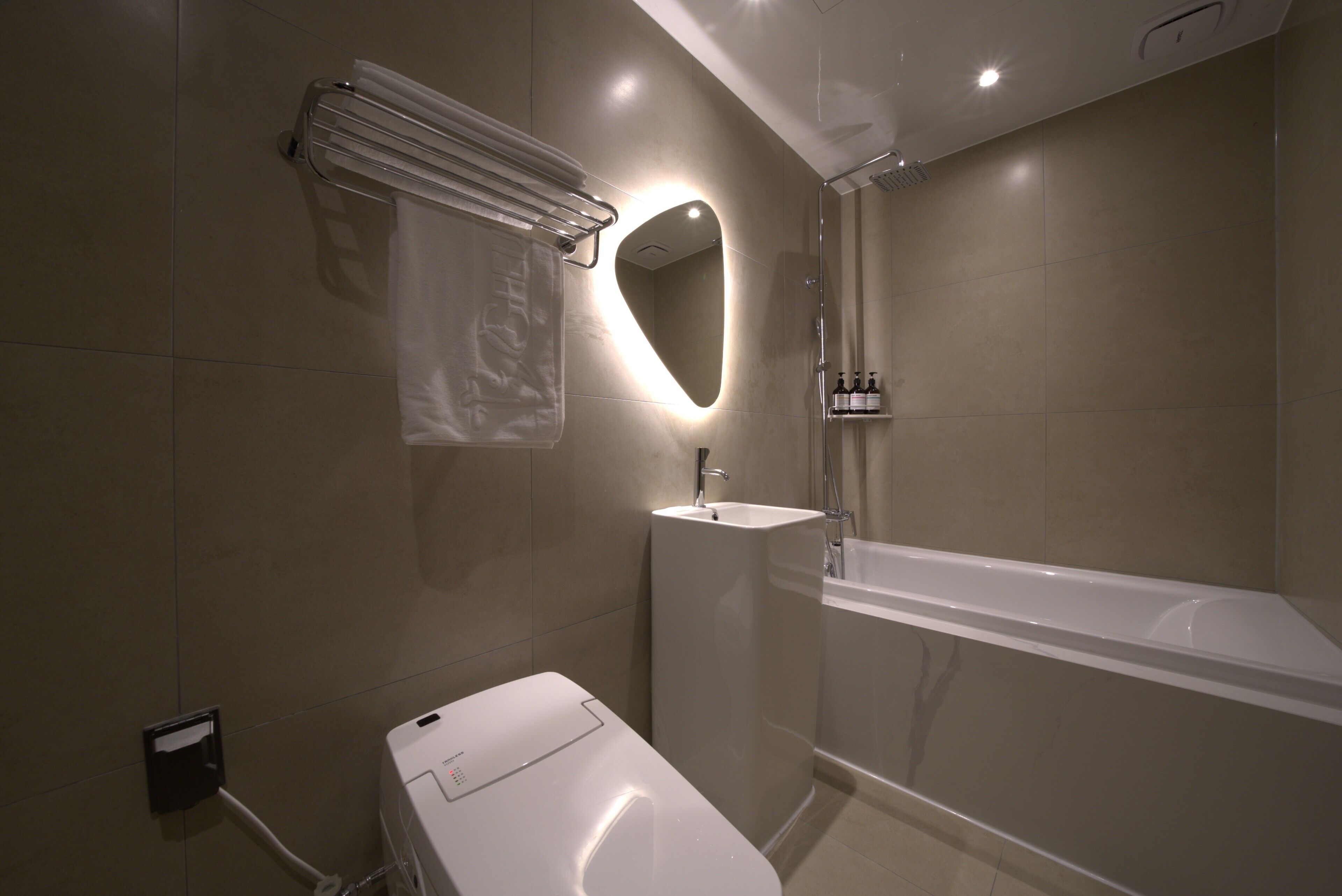 A modern bathroom with a toilet, sink, and bathtub.