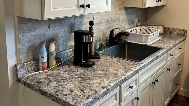 A kitchen with white cabinets, a granite countertop, a coffee maker, and a sink. - Cuddly Critters Cottage - Alpacas, Goats, Emu's and YOU! (Blue Ridge)