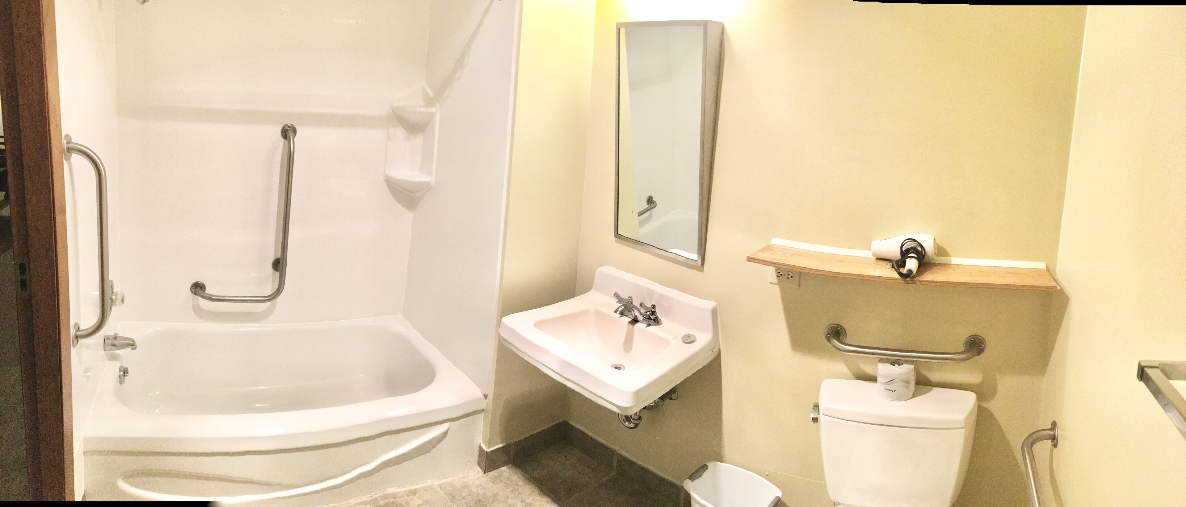 A bathroom with a bathtub, sink, toilet, and a mirror.