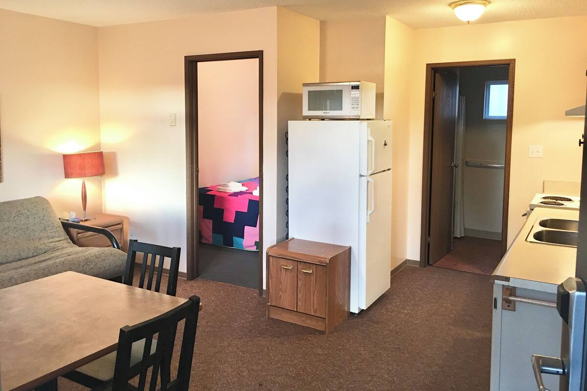 A compact kitchenette with a refrigerator, microwave, and sink.