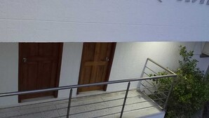 A staircase with metal railings leading to a wooden door.