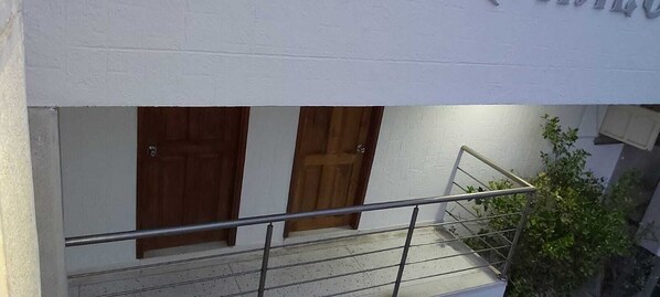 A staircase with metal railings leading to a wooden door. - Habitacion Love, Hermosa Ubicada Cerca de Restaurantes Tipicos (Barranquilla)