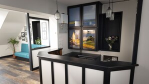 Cocina moderna con encimera negra, lavaplatos integrado y un amplio ventanal con vistas a un edificio y al agua.