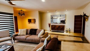 A modern living room with a sofa set, a coffee table, and a decorative mirror. - Ocean-View Rooftop Oasis- Pool, Hot Tub, Fire Pits, 5 minutes to beach & DT Cabo (El Tezal)
