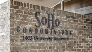 Un mur de briques sur lequel on peut lire : « SoHo Condominiums, 1403, boulevard University ».