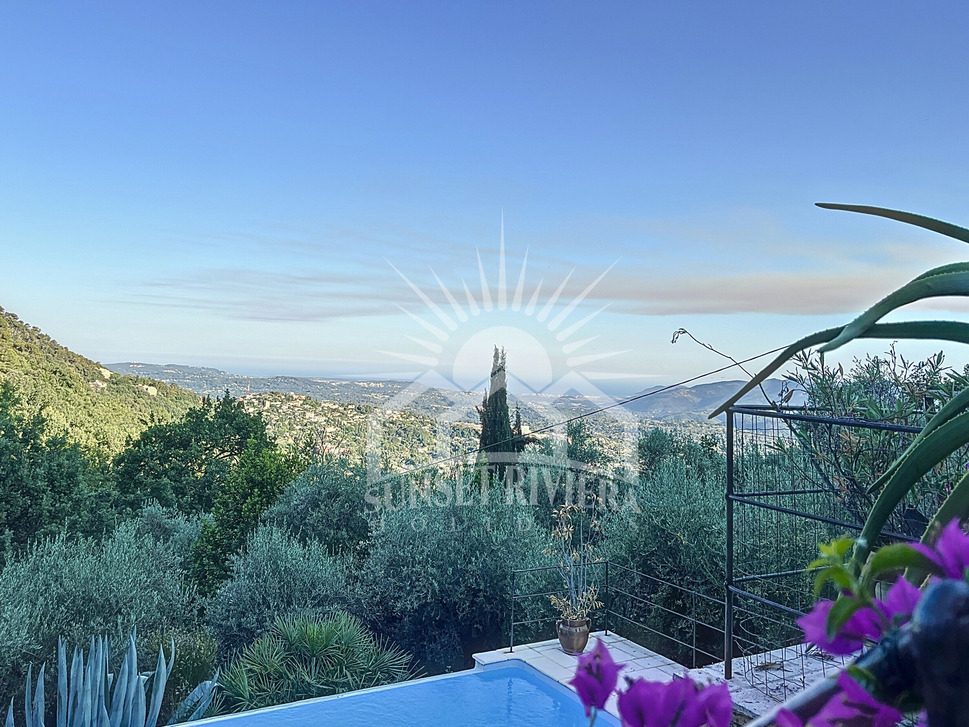 A pool with a view of a cityscape and mountains in the distance.