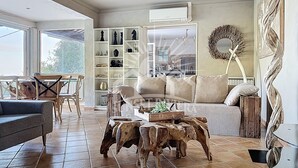Un vaste espace de vie comprenant un canapé, une table basse et des étagères remplies d’objets décoratifs.