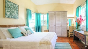 A bedroom with a bed, a wardrobe, a desk, and a chair. - Large pool, gardens and close to beach - Aqua Bliss (Sunset Crest)