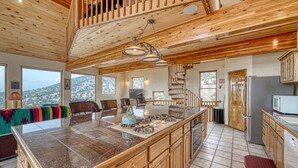A spacious kitchen with a large island, wooden cabinets, and a view of the outdoors. - Mountain Views• Private Hot Tub•Large Deck (Salida)