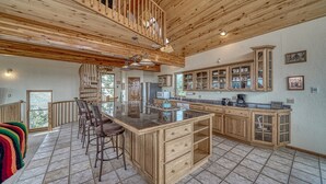 A spacious kitchen with a large island, wooden cabinets, and a high ceiling with exposed beams. - Mountain Views• Private Hot Tub•Large Deck (Salida)