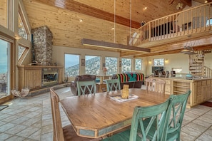 A spacious kitchen with a large island, wooden ceiling, and a stone fireplace. - Mountain Views• Private Hot Tub•Large Deck (Salida)
