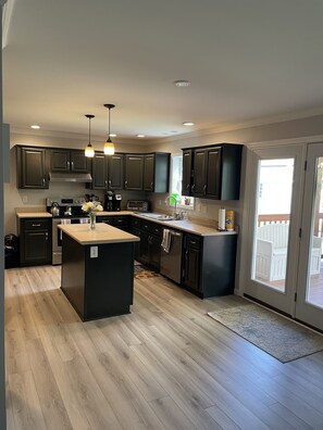 Enjoy cooking in this well-equipped kitchen with a central island, sink, and gas range.