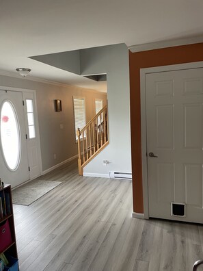Stairs lead to a spacious upper floor with a large window and a door.