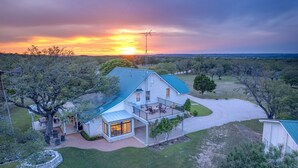 A house with a large deck, a satellite dish, and a well-maintained lawn.
