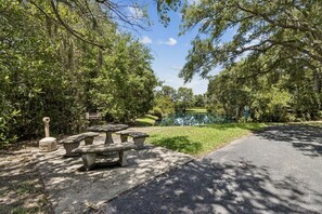 A picnic area with stone benches and a pond.