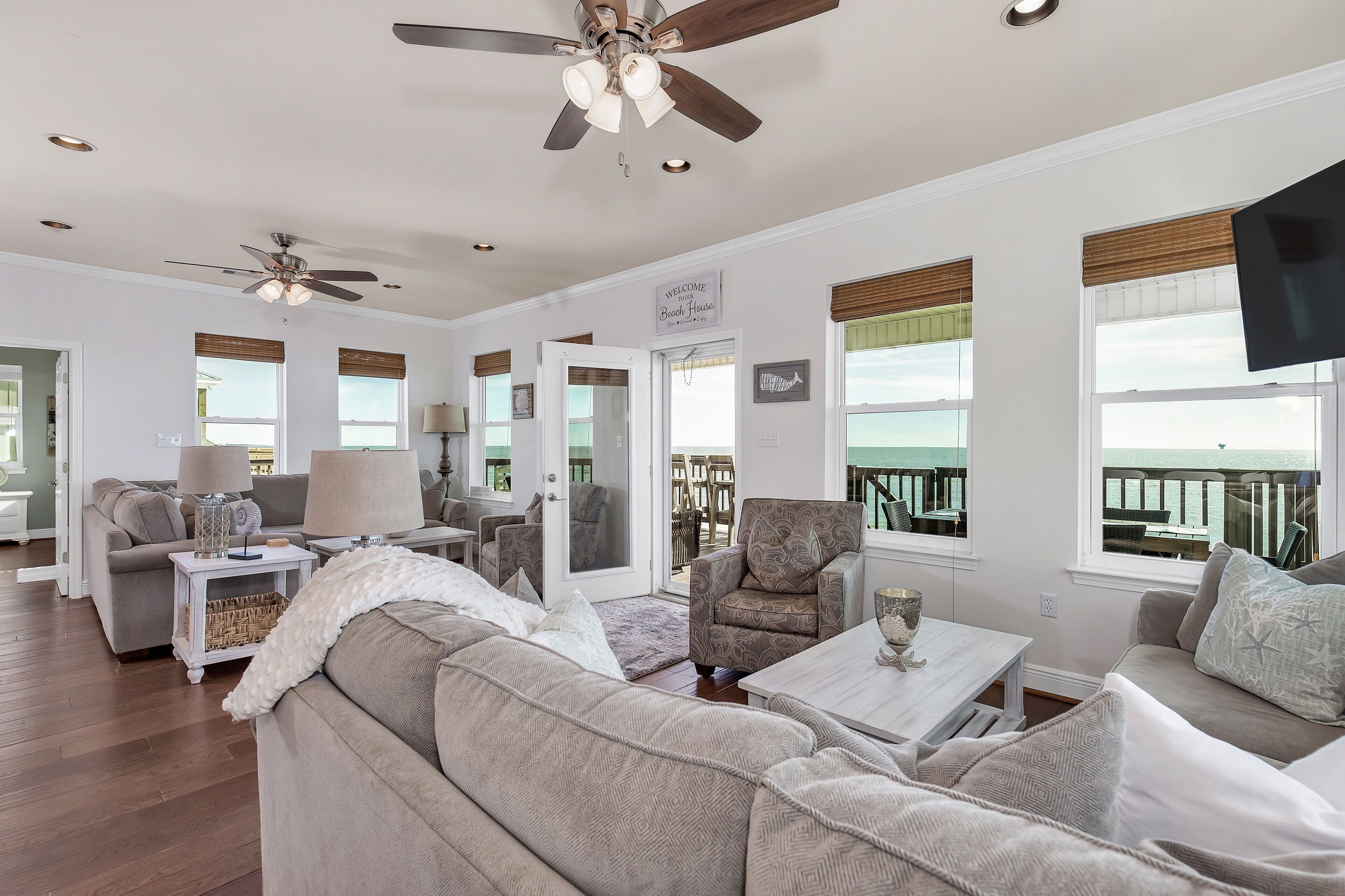 A spacious living room with a ceiling fan, a sofa, a coffee table, and a TV.