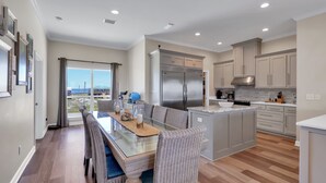 Una cocina moderna con una isla central, electrodomésticos integrados y un comedor con vistas.