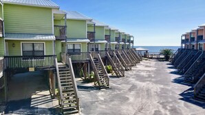 Uma fileira de cabanas à beira-mar, com escadas de madeira que dão para a praia.