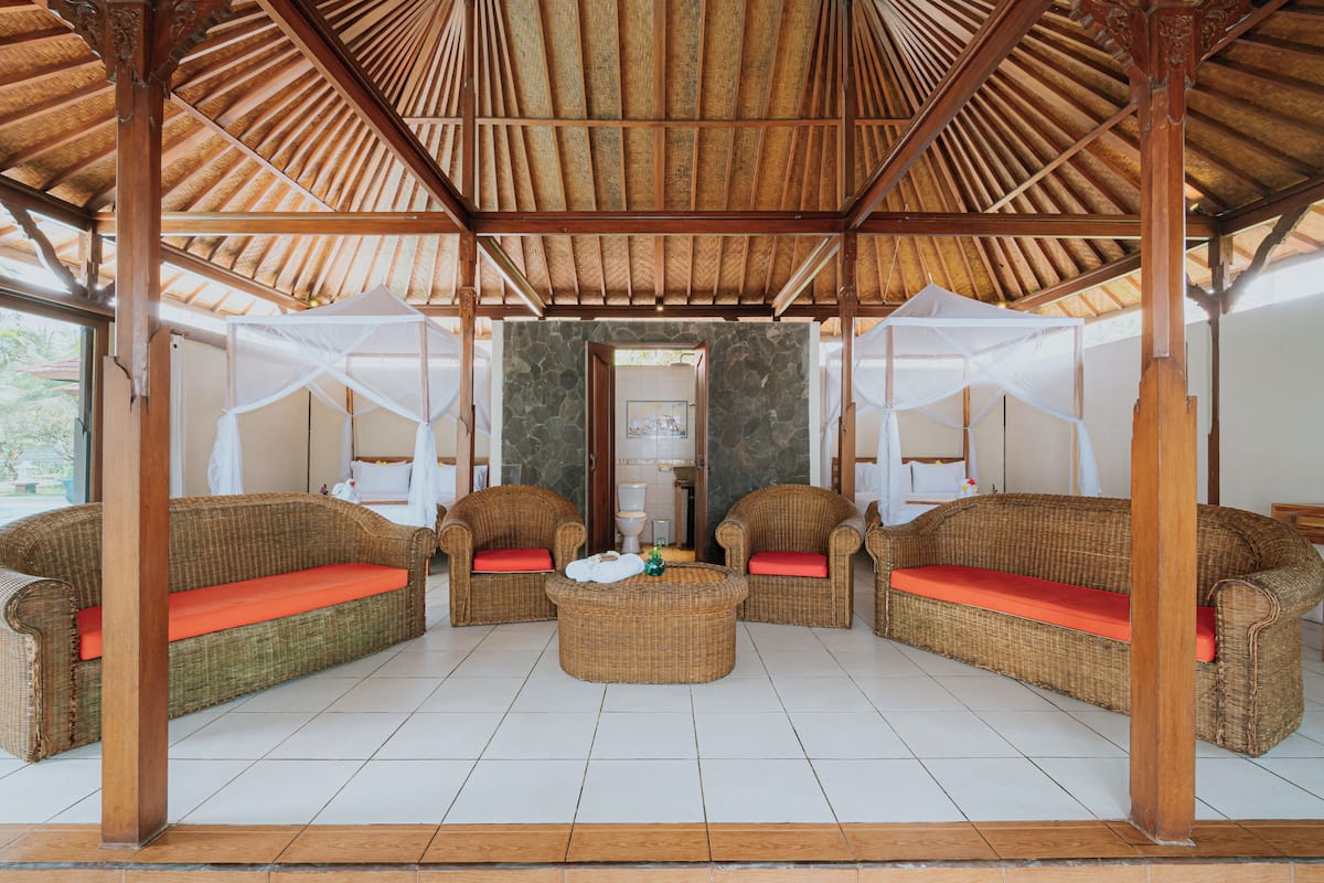 A covered lounge area with wicker furniture and a central coffee table.