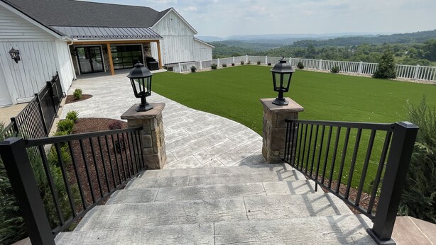 A stone staircase leading to a white building with a covered entrance, surrounded by a fenced lawn and a view of distant hills. - 7 Bedrooms, 2 Houses all for 1 Price, 5 BR Large House & 2 BR Carriage House (Morgantown)