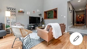 A modern living room with a sofa, a chair, a TV, and a decorative wall hanging. - Peaceful Retreat in Hidden Valley, PA: Ski Resort, Golf and Trails in Mountain (Somerset)