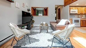 A modern living room with a sofa, two wicker chairs, a coffee table, and a TV. - Peaceful Retreat in Hidden Valley, PA: Ski Resort, Golf and Trails in Mountain (Somerset)