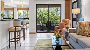 Un salon moderne comprenant un canapé, des fauteuils, une table basse et un coin repas avec des chaises et une table.