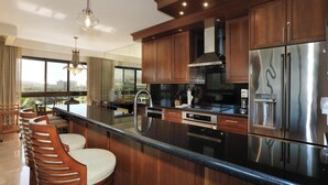 Una cocina moderna con una isla grande, electrodomésticos de acero inoxidable y armarios de madera.