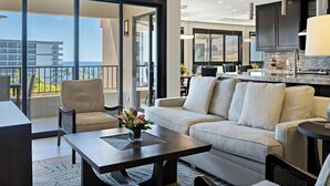 Une chambre d’hôtel moderne dotée d’un balcon, d’un canapé, d’une table basse et d’un coin cuisine.