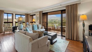 Ein geräumiges Wohnzimmer mit einer großen Couch, Sesseln, einem Couchtisch und einem Balkon mit Blick.