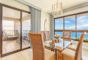 Relax in this stylish room with a glass dining table, wicker chairs, and a balcony offering ocean views.
