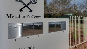Señal de Merchant's Court en el número 21 de Cusack, con buzones del 1 al 6.