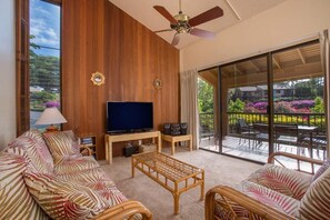 Relax in this inviting space with a large flat-screen TV, wicker coffee table, and comfortable sofa.