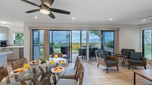 Enjoy breakfast at the dining table with a view of the ocean through large sliding glass doors.