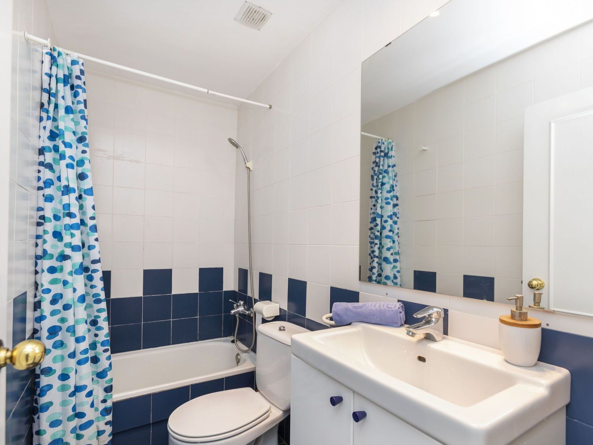 A bathroom with a bathtub, toilet, and sink.