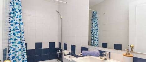 A bathroom with a bathtub, toilet, and sink.